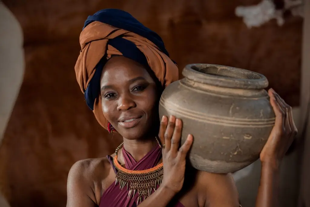 An African woman holding a clay pot