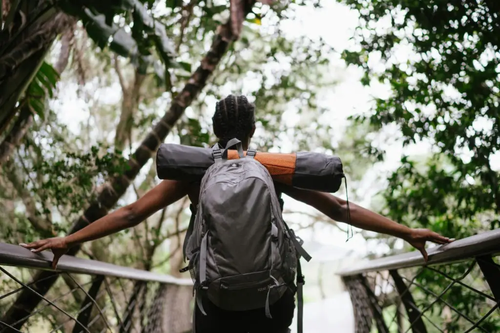 A woman carrying hiking gear on a budget travel in Kenya trip
