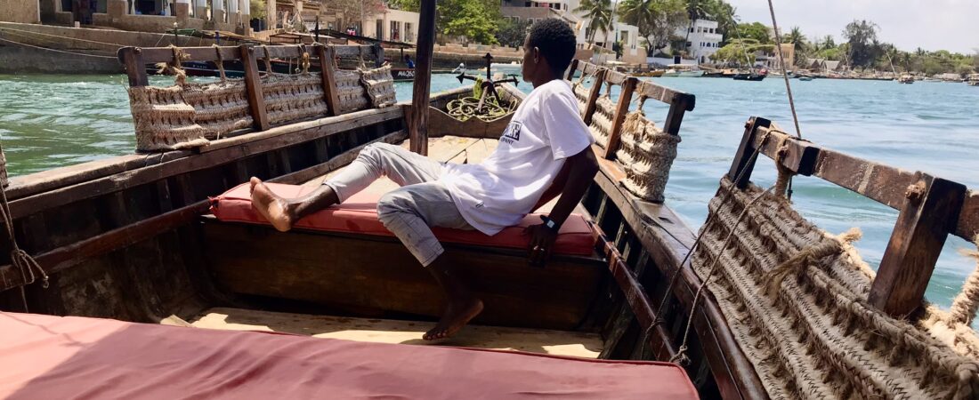 Man boarding a traditional dhow boat in Lamu, Kenya; a popular budget travel in Kenya destination