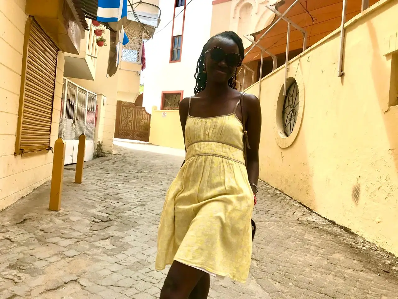A woman in a yellow dress on a budget travel in Kenya trip to Mombasa Old Town