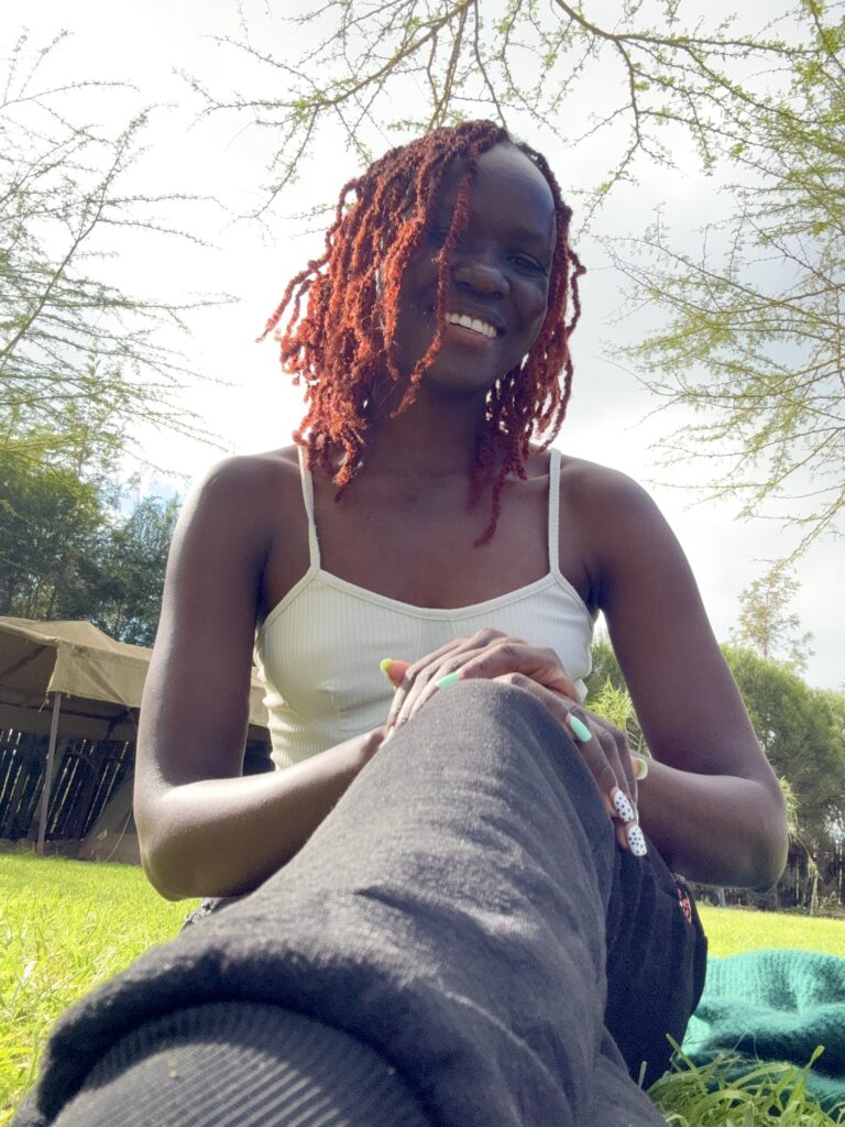 A woman seated on the grass smiling